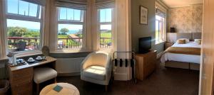 um quarto de hotel com um quarto com uma cama e janelas em Devonia Express em Eastbourne