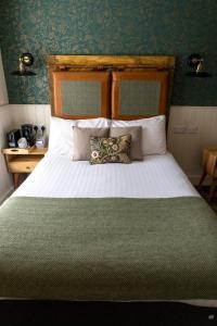 a bedroom with a large white bed with a green blanket at Royal Oak in Dover