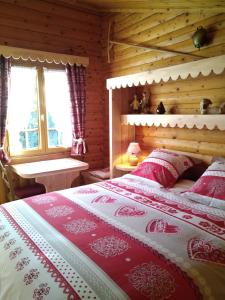a bedroom with a bed with red and white sheets at Chalet Le Paradou Adults only in Lessive