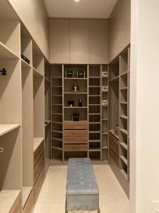 a walk in closet with a bench and shelves at Villa Infinity Denia in Denia +33 photos