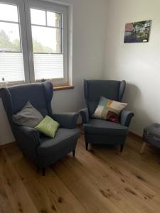 two chairs in a living room with two windows at Landhausidylle in Simmerath