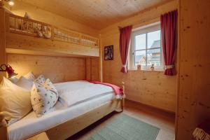 a bedroom with a bed in a log cabin at Narzissendorf Zloam in Grundlsee