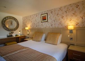a hotel room with a large bed and two lamps at Royal Victoria Hotel Snowdonia in Llanberis