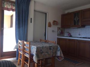 eine Küche mit einem Tisch und Stühlen sowie eine Küche mit einem Fenster in der Unterkunft Studio Montgenèvre, 1 pièce, 4 personnes - FR-1-445-78 in Montgenèvre