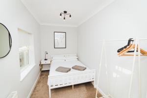 een witte kamer met een bed en een raam bij Newly Refurbished House - 10 Minute Walk From City Centre in Norwich