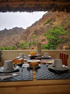 een tafel met eten erop met uitzicht op een berg bij Casa Pedrina in Ribeira Grande