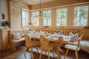 a dining room with a wooden table and chairs at Narzissendorf Zloam in Grundlsee