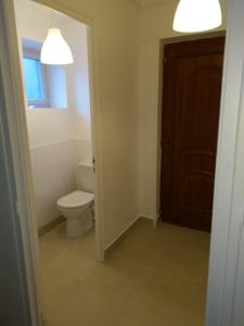 La salle de bains est pourvue de toilettes, d'une fenêtre et d'une porte. dans l'établissement O'Couvent - Appartement 44 m2 - 1 chambre - rdc ext, à Salins-les-Bains