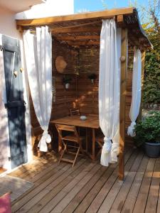 une pergola en bois avec une table en bois sur une terrasse dans l'établissement Une Nuit à Bali - Appartement cocooning, à Solliès-Toucas