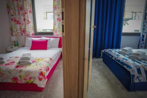 a small bedroom with a bed with a pink pillow at Lemmas Apartament Anchoria in Mechelinki