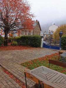 un banco sentado en una pasarela de ladrillo junto a una casa en Mirabeau en Le Mont-Dore