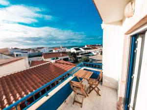 a balcony with two chairs and a table on a building at Be Baleal Surfhouse in Baleal