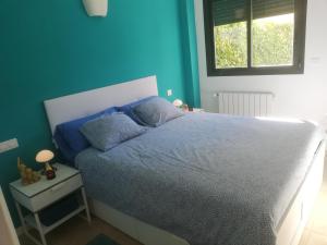 ein Schlafzimmer mit einem Bett mit einer blauen Wand in der Unterkunft gelijkvloers appartement Corvera Golf & Country Club in Corvera + 65 Fotos