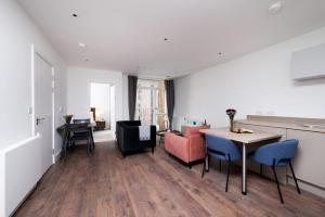 sala de estar con mesa y sillas en Modern Studios and Apartments at Barking Wharf in London en Londres