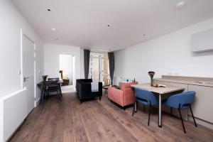 a living room with a table and chairs at Modern Studios and Apartments at Barking Wharf in London in London