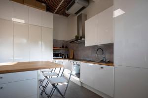 a kitchen with white cabinets and a wooden counter top at Enjoytoday vakantiewoning 45 in Oudenaarde