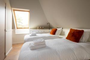 two white beds in a room with a window at Enjoytoday vakantiewoning 45 in Oudenaarde