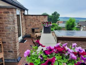 a patio with pink flowers and a table and chairs at Auberge A gen Kirk B&B in Vijlen +48 photos