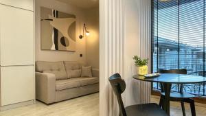 een woonkamer met een tafel en een bank bij Comfortable 1-room apartment close to the center in Warschau