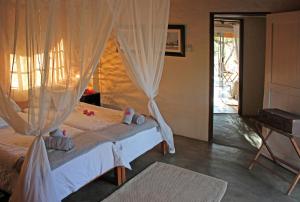 a bedroom with a bed with a mosquito net at KwaMbili Game Lodge in Thornybush Game Reserve