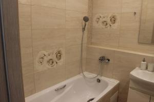 ein Badezimmer mit einer Badewanne und einem Waschbecken in der Unterkunft Квартира в Вышгороде для души in Wyschhorod