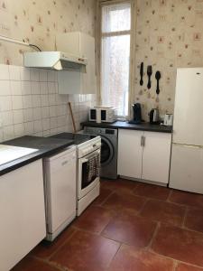 a kitchen with white cabinets and a dishwasher at Chez Benjamin - Centre d'Azay le Rideau in Azay-le-Rideau