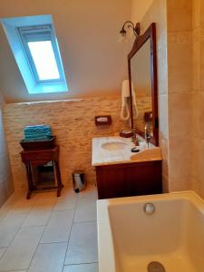 a bathroom with a sink and a mirror and a tub at Hôtel Le Manoir De Mathan Crépon à la campagne 5 mn d'Arromanches et 10 mn de Bayeux in Crépon