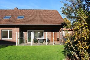 a brick house with a patio with a table in the yard at Schwabe, Ferienwohnung in Schneverdingen