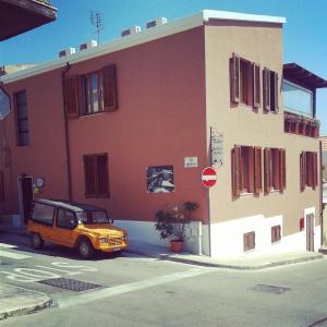 un jeep naranja estacionado frente a un edificio en B&B Il Porto Vecchio en Stintino