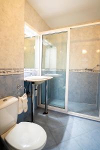 a bathroom with a toilet and a shower and a sink at Globus Hotel in Plovdiv