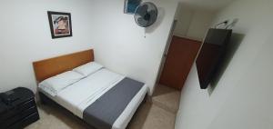 um pequeno quarto com uma cama e uma televisão em Hotel Gran Imperio em Medellín