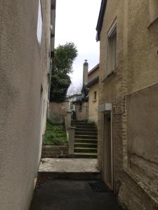 an alley between two buildings with stairs in the distance at Hébergement à l'Orée des Champs in Rethel