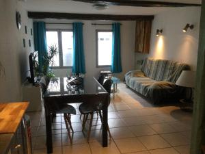 a living room with a table and a couch at Hébergement à l'Orée des Champs in Rethel