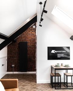 ein Wohnzimmer mit einem Tisch und einer Ziegelwand in der Unterkunft Urban Loft Apartment • 1 Bedroom • Manchester in Ashton under Lyne