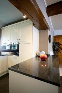 a kitchen with white cabinets and an apple on a counter at Enjoytoday 49 - Luxueus familieverblijf aan de voet van de Koppenberg in Oudenaarde