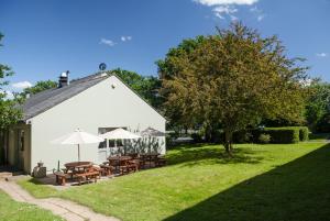 a white building with tables and umbrellas in a yard at Campanile Hotel - Basildon - East of London in Basildon