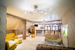 a living room with yellow furniture and a chandelier at Globus Hotel in Plovdiv