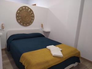 AjuyにあるApartamento Ajuyのベッドルーム1室(黄色と青の毛布付きのベッド1台付)