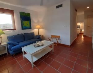 a living room with a blue couch and a table at miKasa Agua Amarga & SPA in Agua Amarga