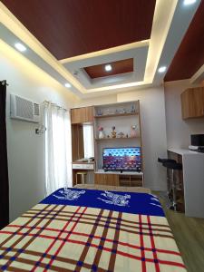 Schlafzimmer mit einem Bett und einem Flachbild-TV in der Unterkunft Antara Residentials and Condominium in Talisay