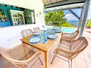 een houten tafel en stoelen op een patio bij Moonstone, private room in Villa Casa Blue pool sea view in Koolbaai
