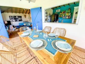 a dining room table with chairs and plates on it at Moonstone, private room in Villa Casa Blue pool sea view in Koolbaai