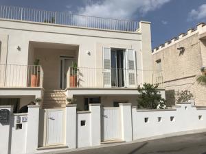 a white fence in front of a house at Estatesalento in Leuca