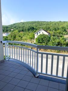 a white railing on a balcony with a view of a house at Maslina Apartments in Široki Brijeg