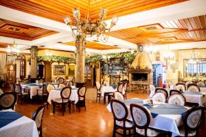 a dining room with tables and chairs and a fireplace at Globus Hotel in Plovdiv