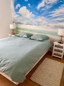 um quarto com uma cama com uma pintura do oceano em Appartement lumineux 6 places avec vue sur Marina em Mandelieu-la-Napoule