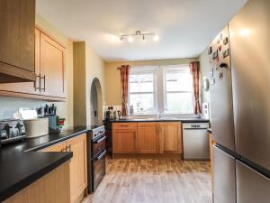 a kitchen with wooden cabinets and a stainless steel refrigerator at 62 Society Street in Nairn
