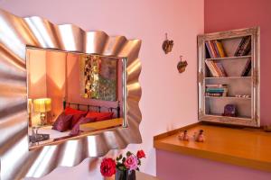 a bedroom with a mirror and a bed with red pillows at Kaiti`s House in Skiathos