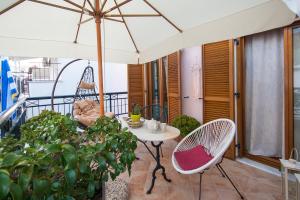 un balcon avec une table, des chaises et un parasol dans l'établissement Kaiti`s House, à Skiathos Chora