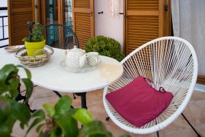 a white table with two chairs and a white table with a red pillow at Kaiti`s House in Skiathos